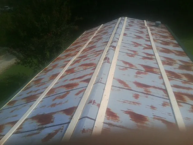 Rusted metal roof panels with new wood purlins before replacement — Storm Damage Roof Repair in Northwood by Roofing Brothers