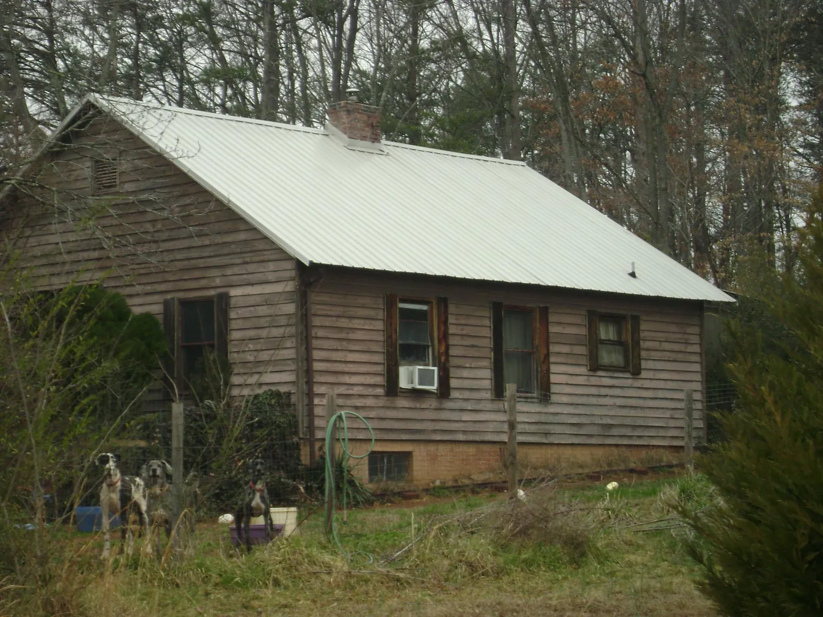 White metal roof on an old wood sided farmhouse, from a Metal Roof Installation job in Northwood